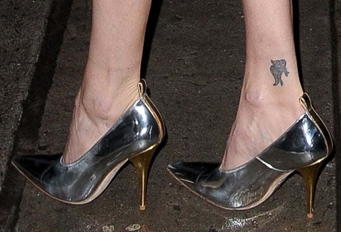 Charlize Theron shows off her ankle tattoo in Burberry pumps