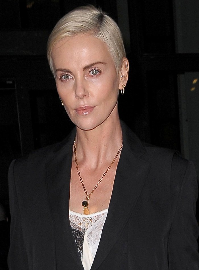 Charlize Theron wears a side-parted blonde pixie with nude lip gloss