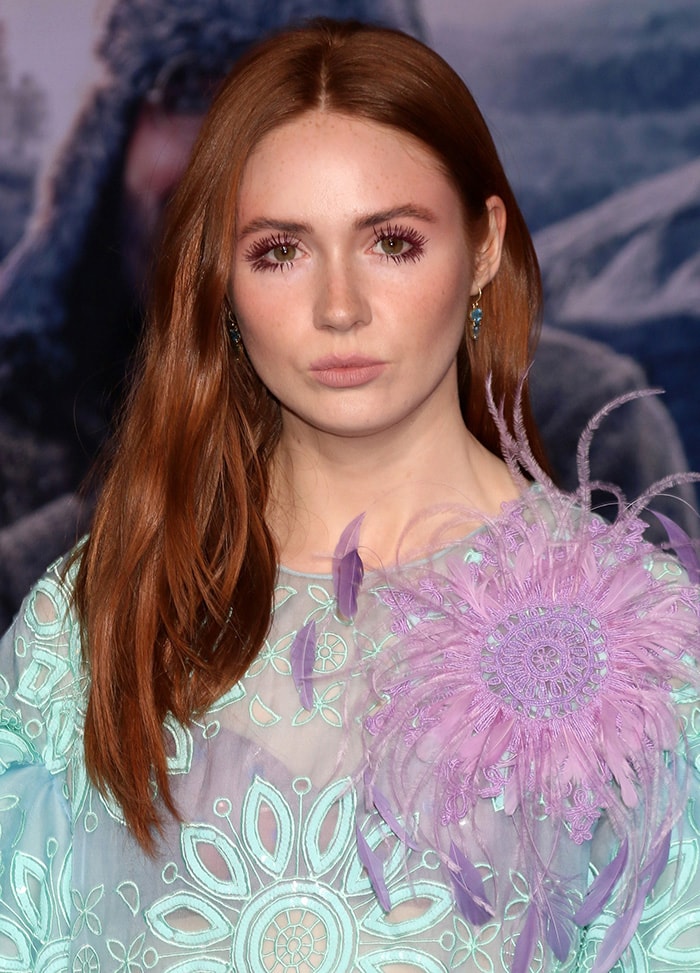 Karen Gillan wears her red hair down over one shoulder with nude makeup look