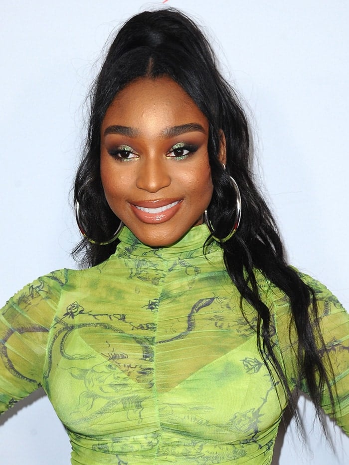 Normani wears half ponytail hairstyle with extensions and coordinating green eyeshadow 