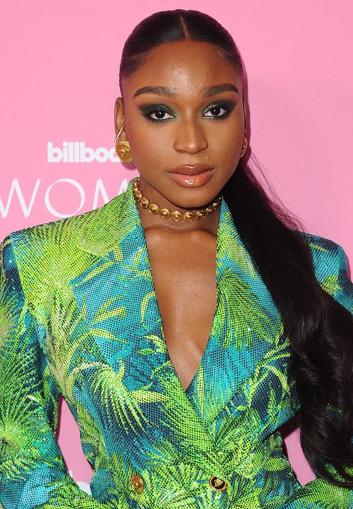 Normani wears a slicked center-parted ponytail with smoky winged eye-makeup