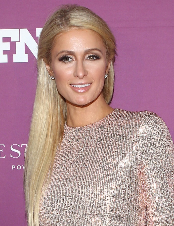 Paris Hilton styles her long blonde hair straight with glittery eyeshadow