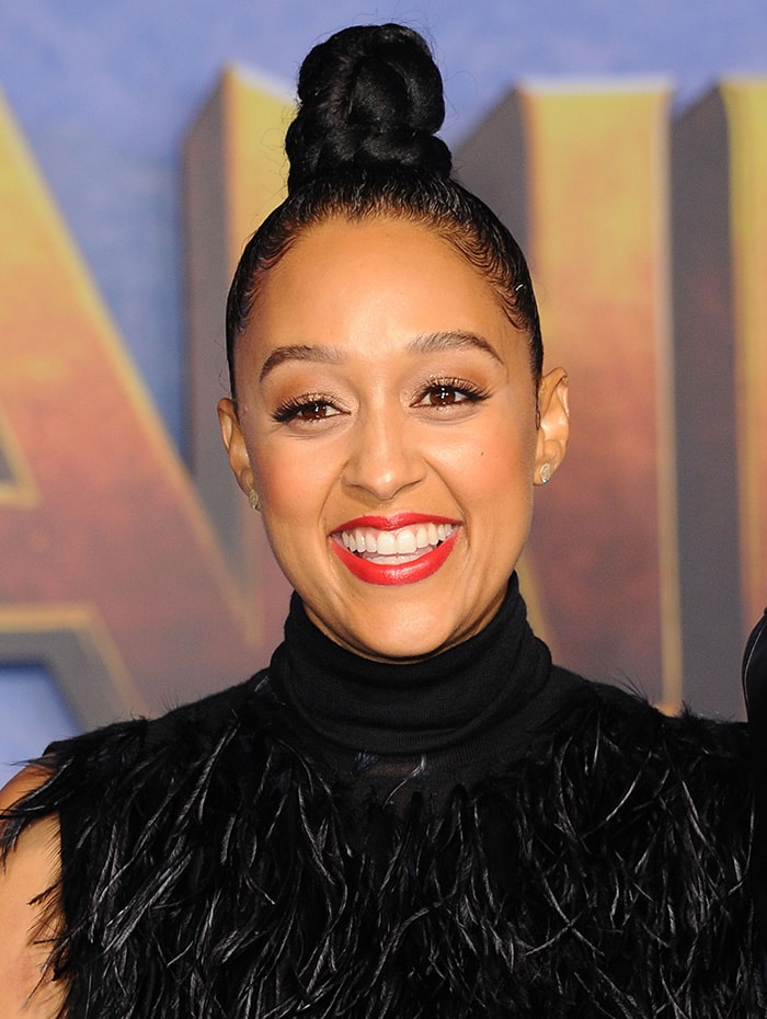 Tia Mowry pulls her hair up in a knotted bun