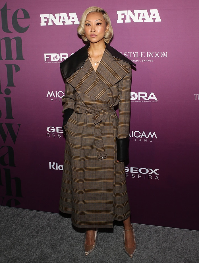 Vanessa Hong looks chic in a leather-trimmed plaid trench coat 