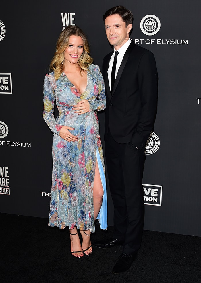 Ashley Hinshaw, glowing in a floral-printed gown with a thigh-high slit, and her husband, Topher Grace, looking sharp in a classic black suit, were honored with the Spirit of Elysium award at the 2020 Art of Elysium Gala on January 4, 2020