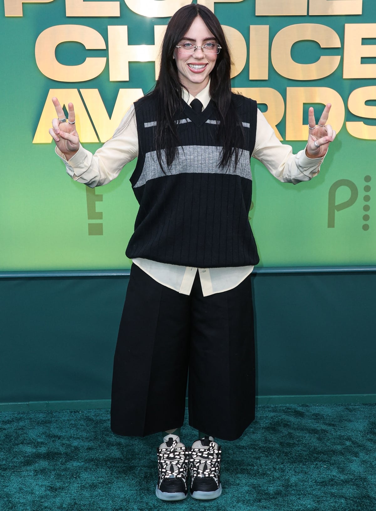At the 2024 People's Choice Awards at Barker Hangar on February 18, 2024, in Santa Monica, California, Billie Eilish wore an oversized striped sweater vest, ankle-length shorts, and platform sneakers