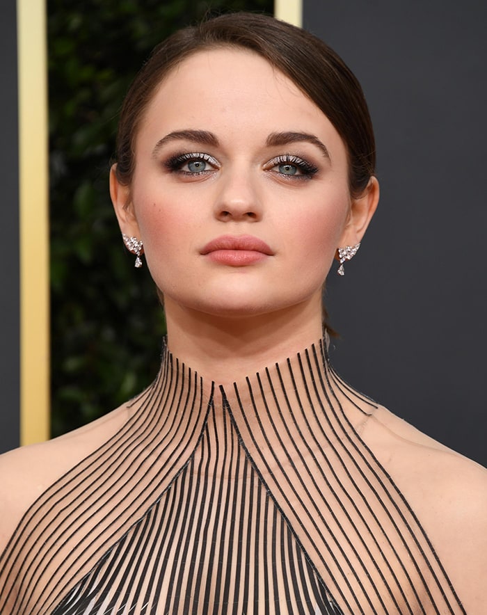 Joey King wears a chic updo with smoky eye-makeup and nude rose lipstick