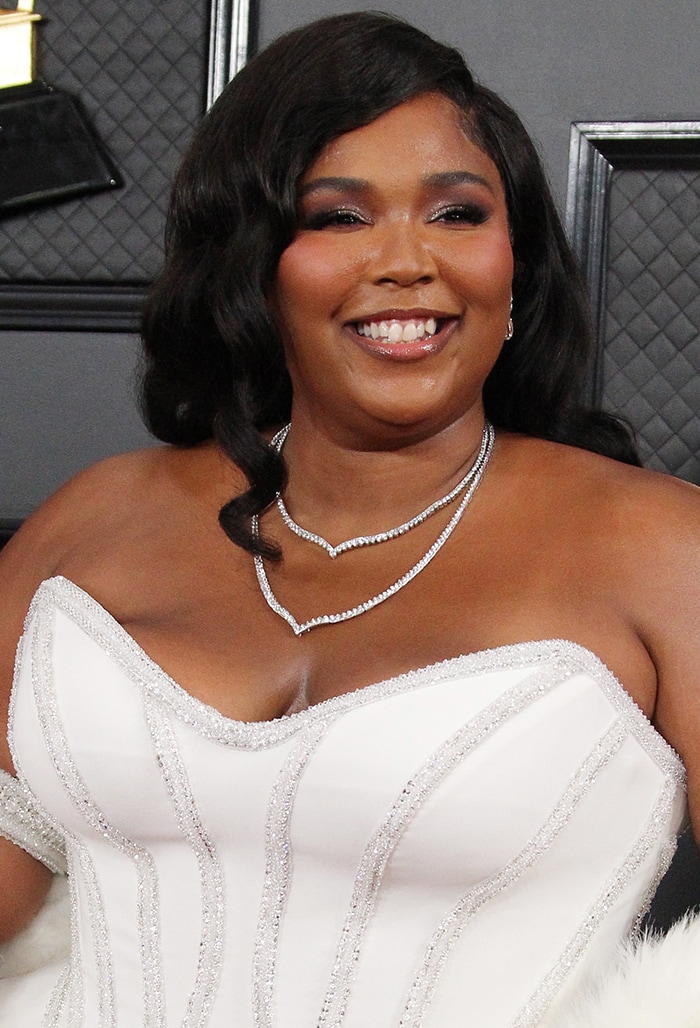 Lizzo wears vintages curls with purple smoky eyeshadow and false eyelashes