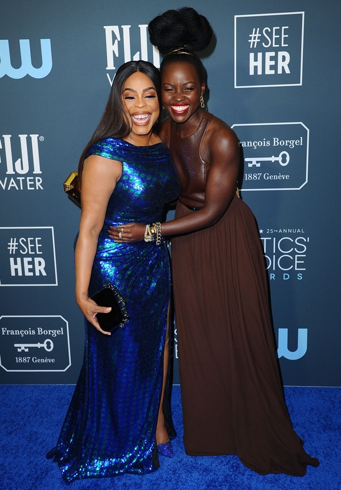 Lupita Nyong'o sharing a laugh with Niecy Nash at the 2020 Critics’ Choice Awards