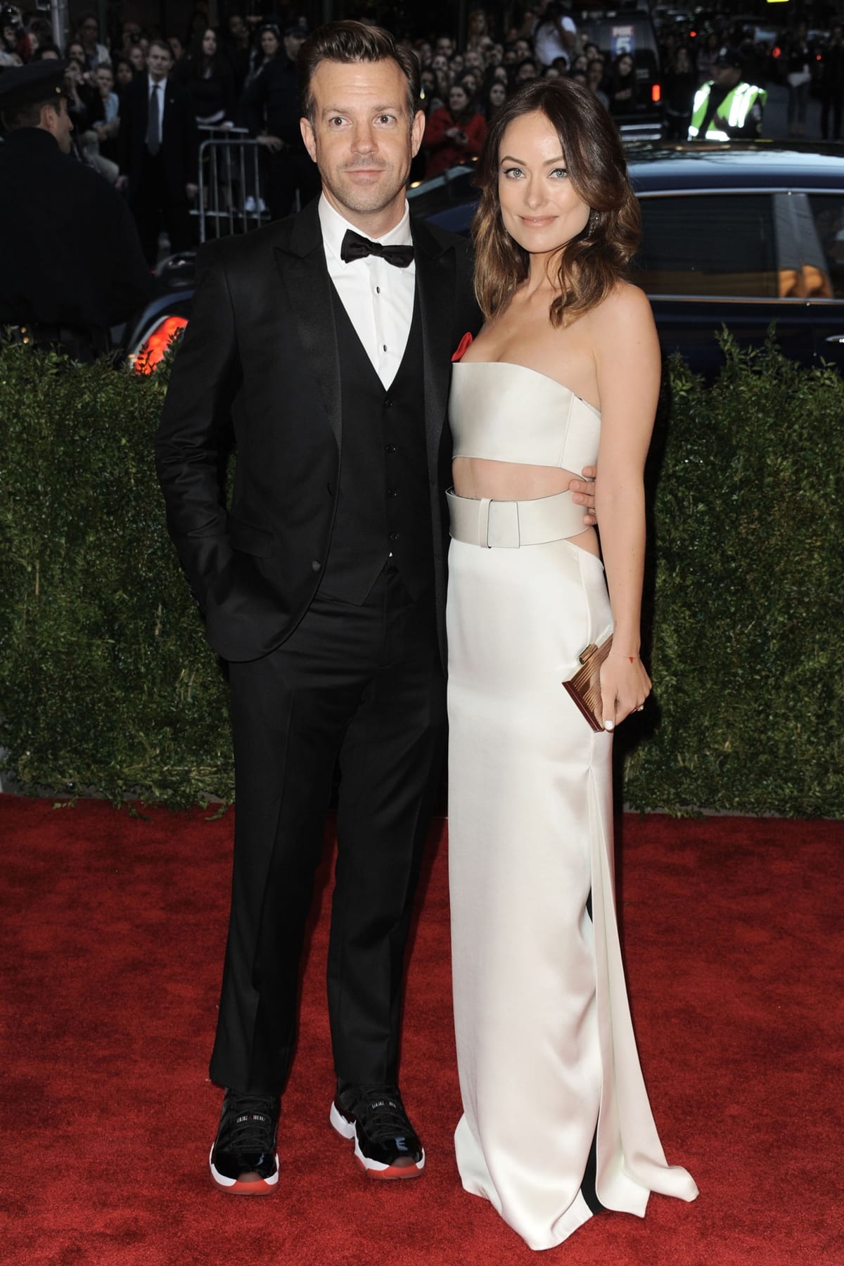 Olivia Wilde, wearing a custom Calvin Klein Collection ivory matte satin bandeau dress with black pleats, heels, and clutch with Fred Leighton jewelry, and Jason Sudeikis attend the Costume Institute Gala for the "PUNK: Chaos to Couture" exhibition at the Metropolitan Museum of Art