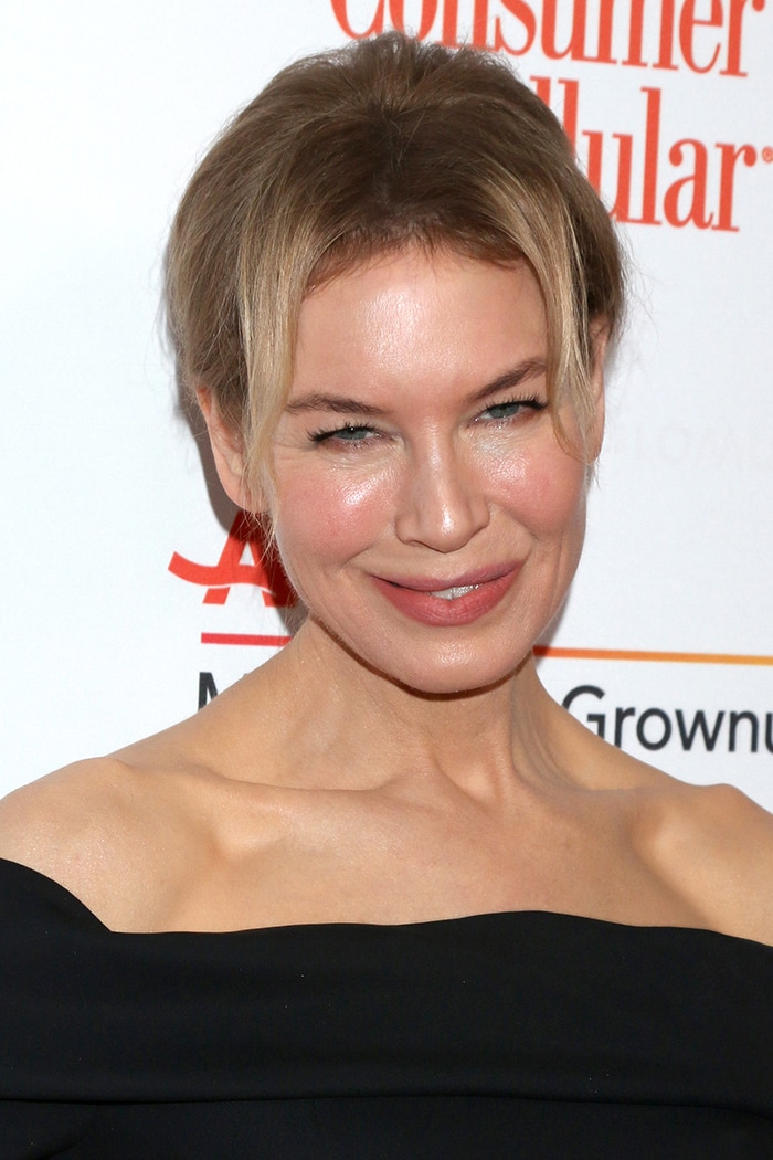 Renee Zellweger pulls her hair up in a chic bun and wears rosy lipstick and blush