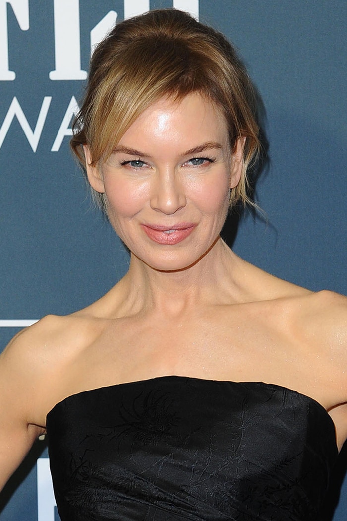 Renée Zellweger wears a chic, messy ponytail with soft pink makeup