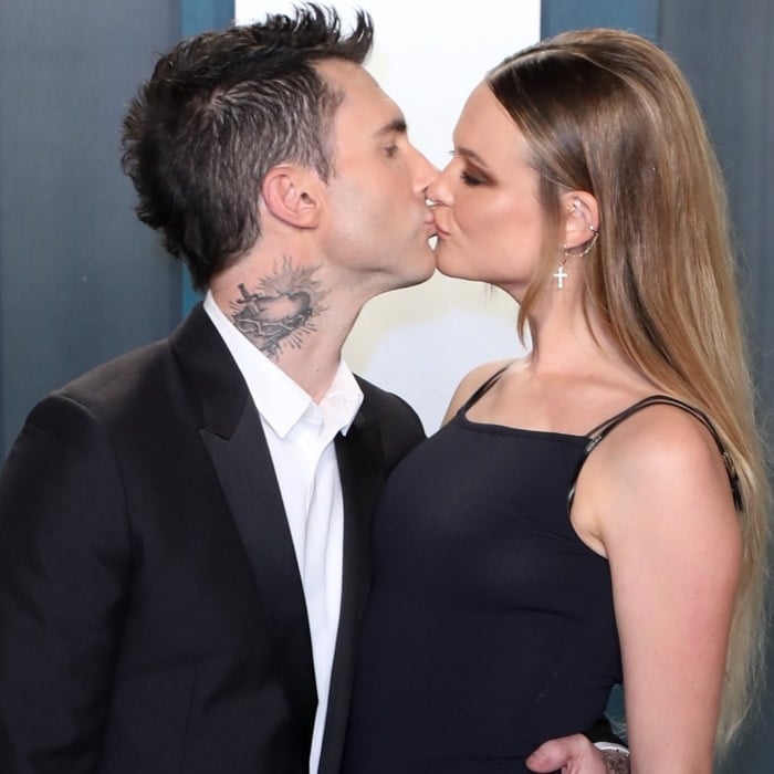 Behati Prinsloo and Adam Levine share a tender kiss, capturing the love and chemistry between the model and Maroon 5 frontman