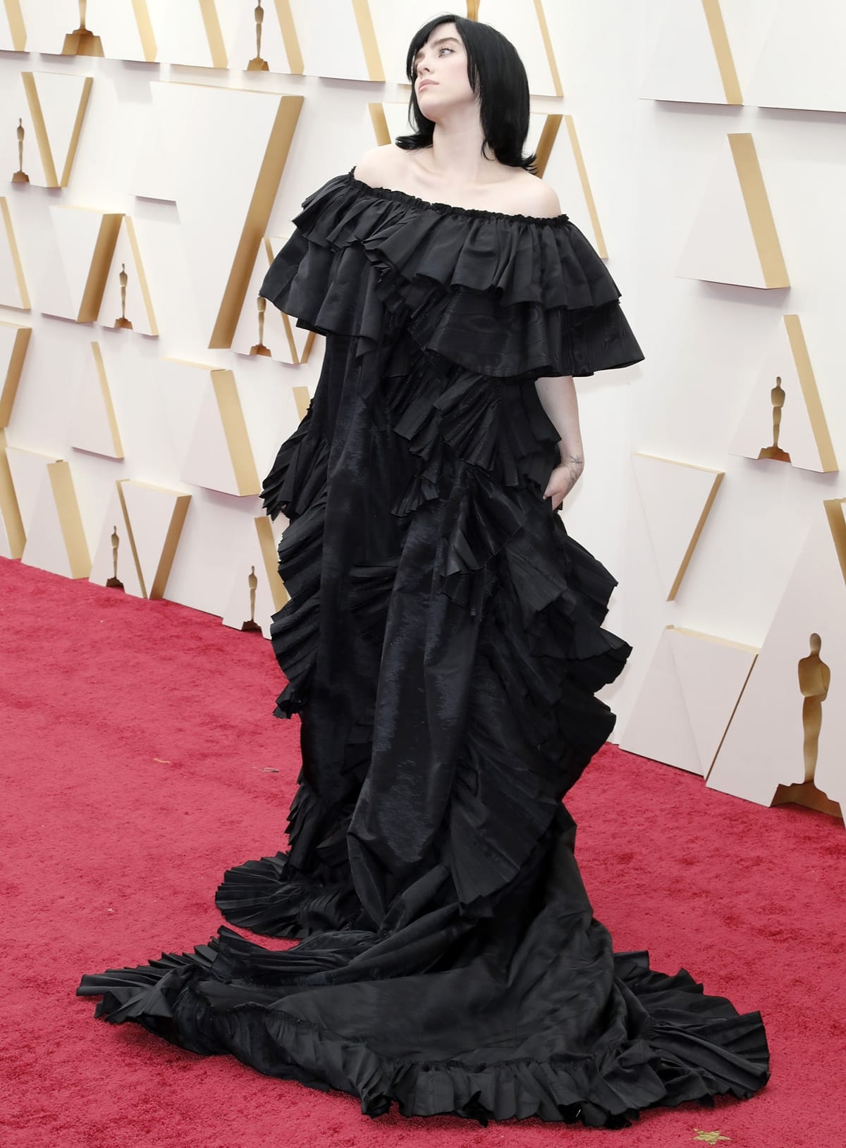 Billie Eilish wore a custom black off-the-shoulder Gucci gown featuring dramatic ruffles and a long train