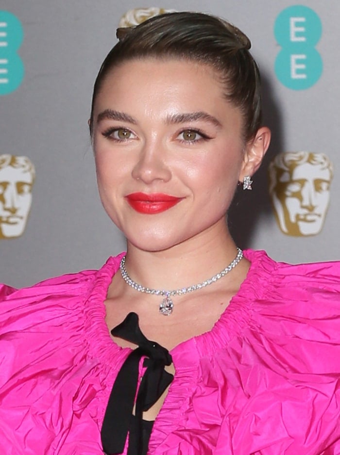 Florence Pugh wears a sleek updo with red lipstick