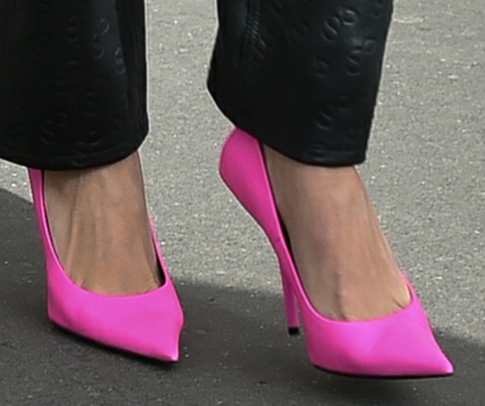 Hailey Bieber adds a pop of neon pink color to the look with Balenciaga pumps