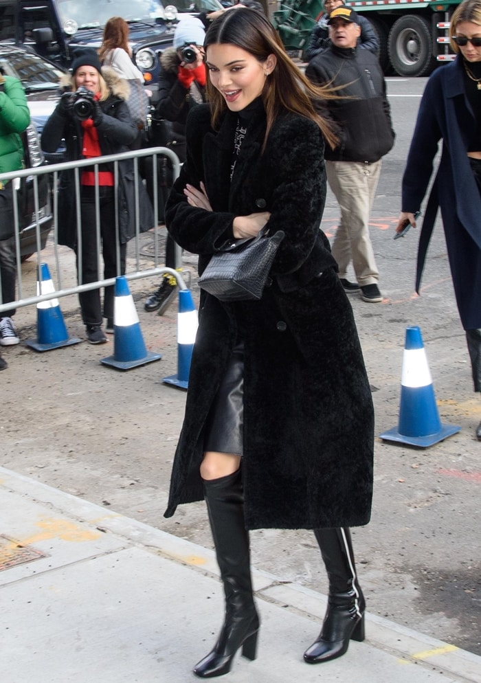 Kendall Jenner wears a Balenciaga coat in dyed lamb shearling fur outside Longchamp