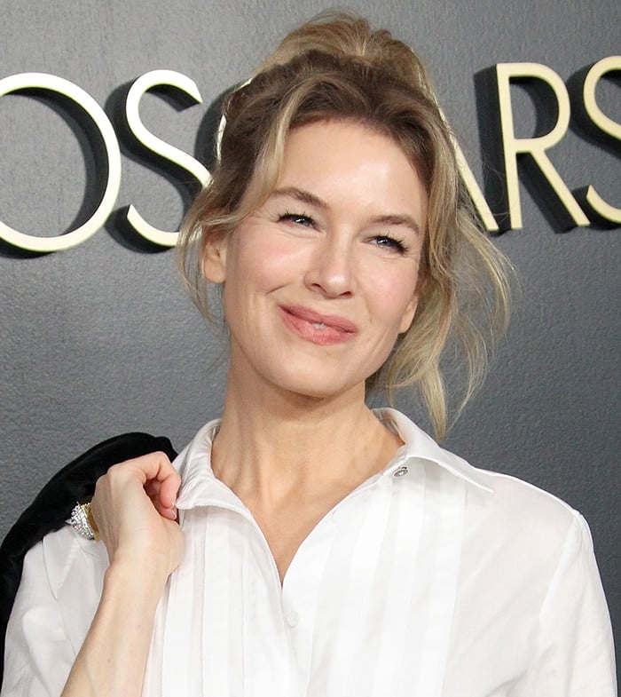 Renee Zellweger wears a messy high ponytail and barely-there makeup