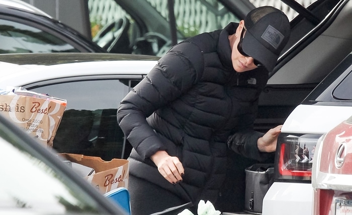 Charlize Theron wears a black stretch down jacket from The North Face