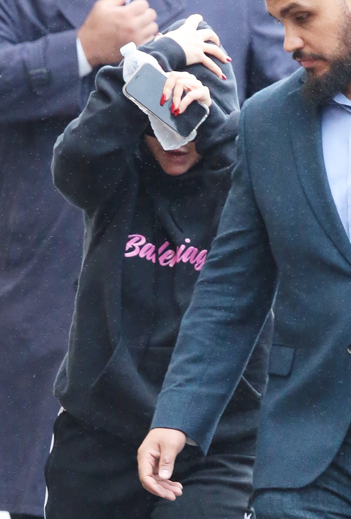 Christina Aguilera covered her platinum blonde hair underneath a glossy back pulled hoodie in washed black and pink printed brushed fleece