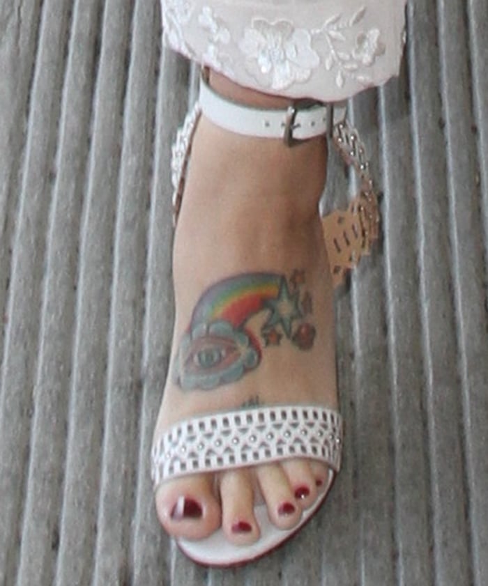 Kesha's rainbow tattoo with stars and planet Saturn on one end and cloud with eye on the other
