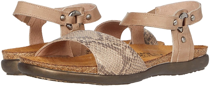 An earthy sandal is fashioned with burnished stud hardware and a curved, comfort-focused footbed to serve as a casual-chic go-to style