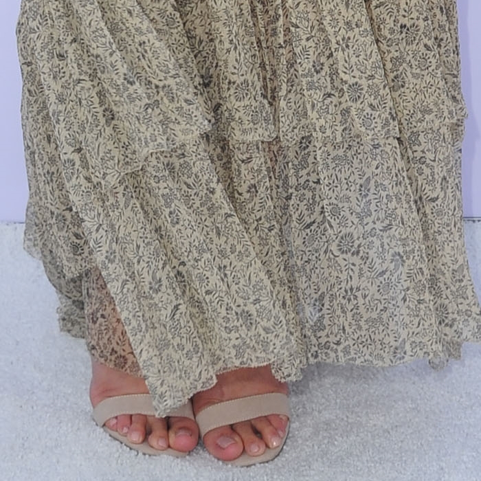 Lauren Conrad's glossy nude pedicure and minimal ankle-strap heels create a leg-lengthening illusion beneath her floral maxi dress—an effortlessly elongating combo that blends polish with boho charm