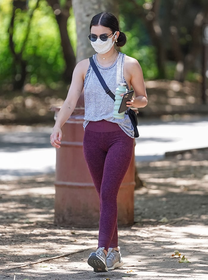 Lucy Hale flaunts her toned arms in a gray tank top and burgundy leggings