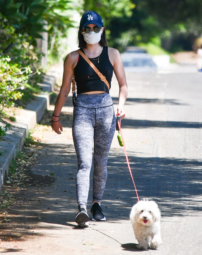 Lucy Hale wears a black crop tank top with leggings as she walks her dog Elvis in Los Angeles on May 11, 2020