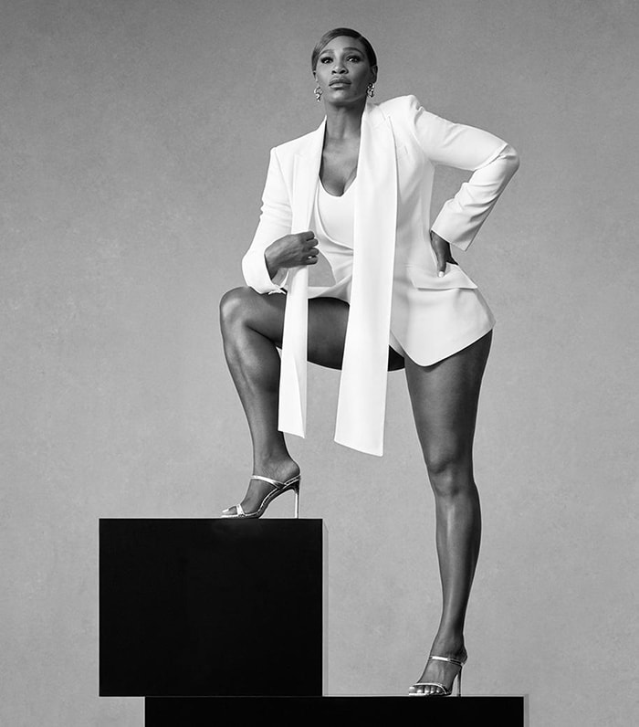 Serena Williams wearing a bodysuit and a blazer with Stuart Weitzman sandals