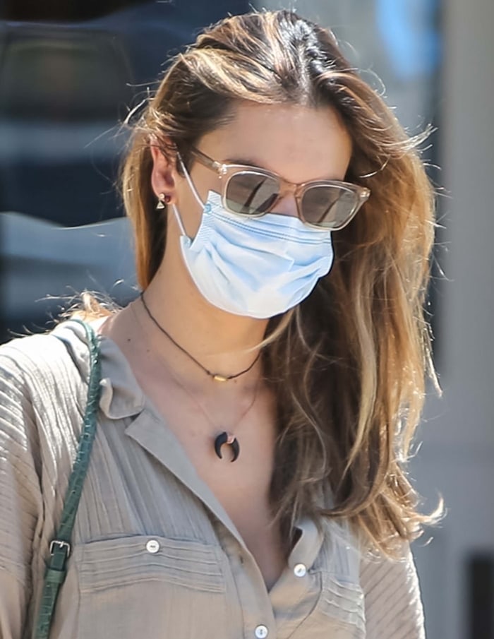 Alessandra Ambrosio exudes casual elegance in her olive-toned blouse, Garrett Leight x Clare V. Nouvelle sunglasses, and layered necklaces during a relaxed outing