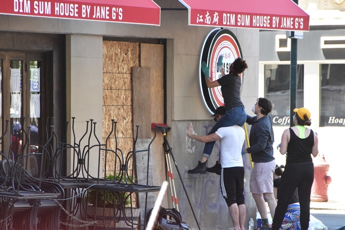 Citizens help to clean up graffiti and debris in downtown Philadelphia on May 31, 2020, after riots the night before in protest of the killing of George Floyd