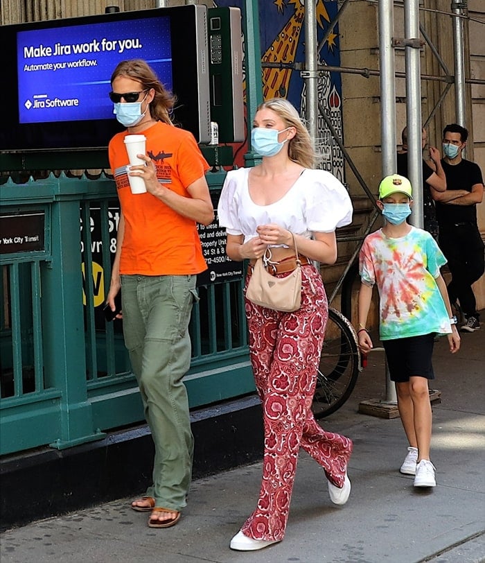 Elsa Hosk rocks paisley print pants featuring a flared style, a front button fastening, a waistband with belt loops, two front pockets, rear pockets, and a branded rear patch