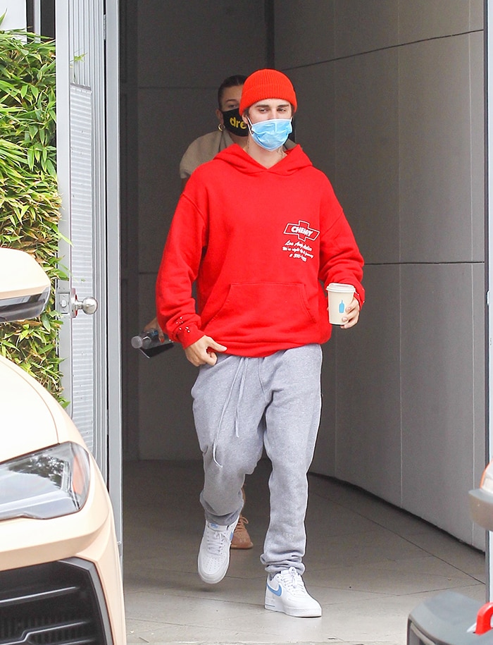 Justin Bieber in gray sweatpants with a red sweatshirt and matching beanie