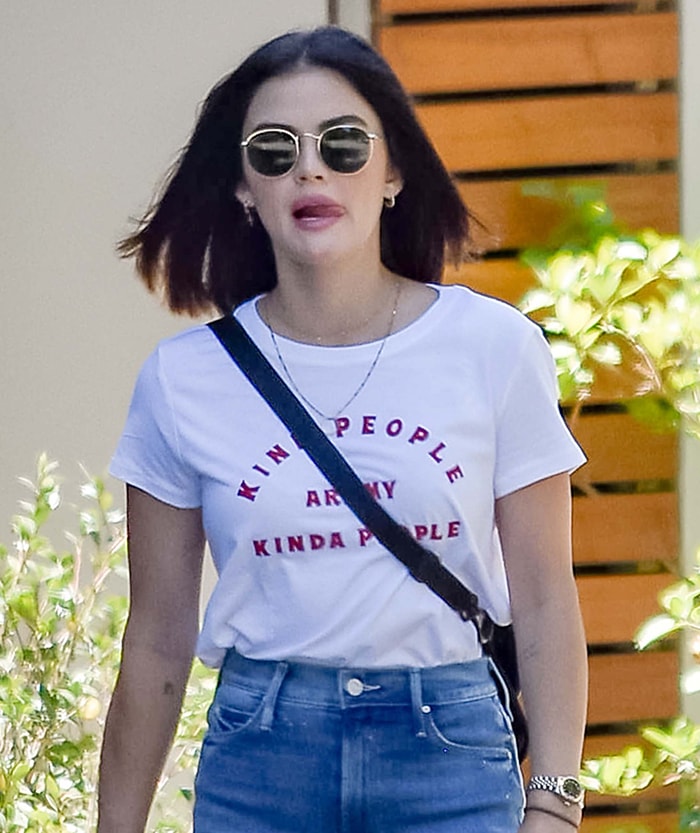 Lucy Hale accessorizes with gold jewelry, Ray-Ban sunnies, and a Rolex watch