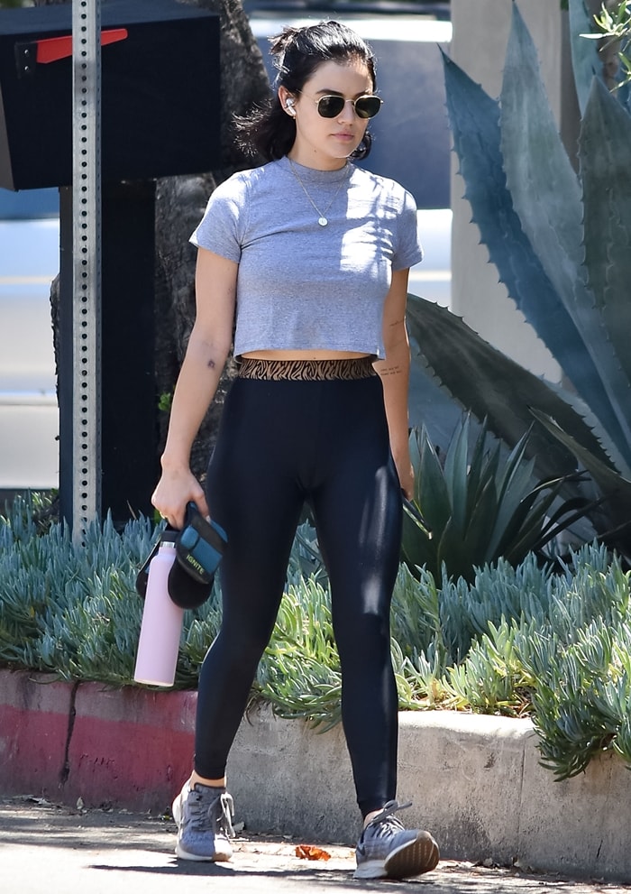 Lucy Hale keeps it sporty and stylish in gray Nike Air Zoom Pegasus 36 sneakers, black leggings with a zebra-print waistband, and a cropped gray tee during a casual outing in Los Angeles on June 12, 2020