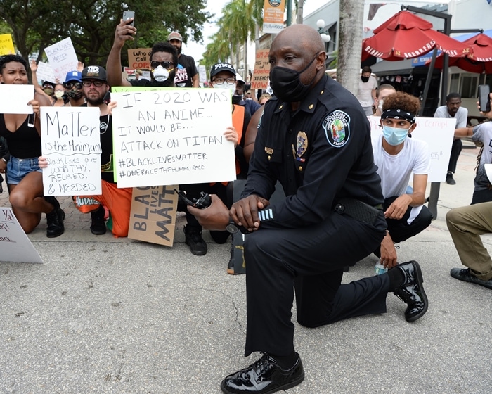 A police officer joins protesters demonstrating peacefully during the protests for George Floyd