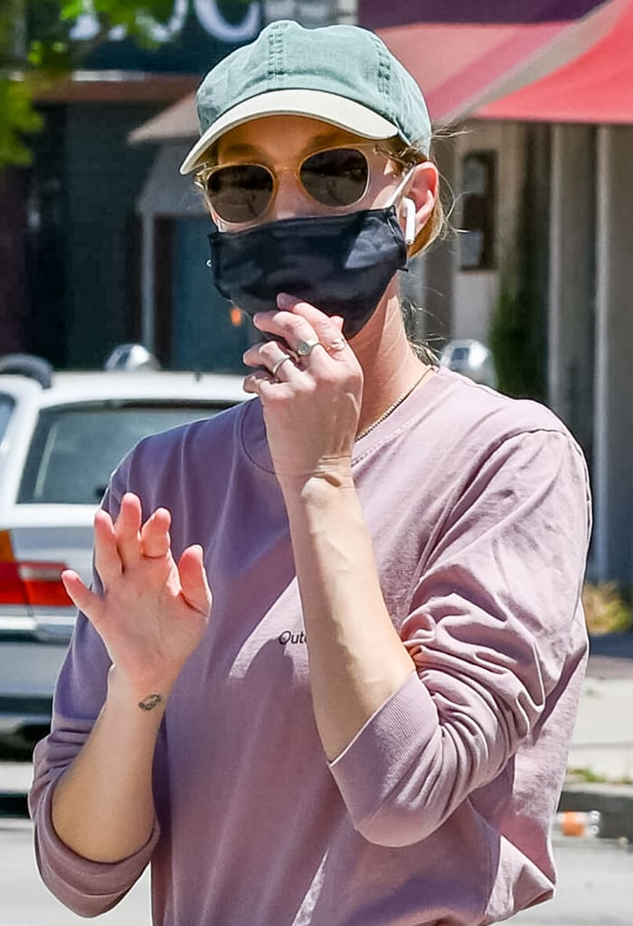 Whitney Port wears a black face mask for protection against coronavirus