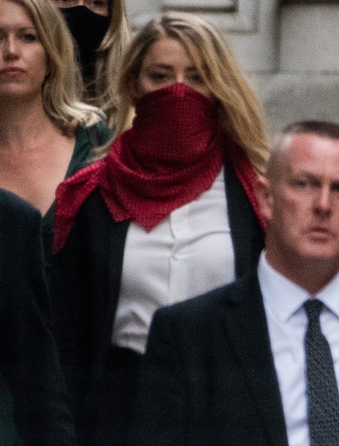 Amber Heard styles her black-and-white power suit with a red dotted scarf mask