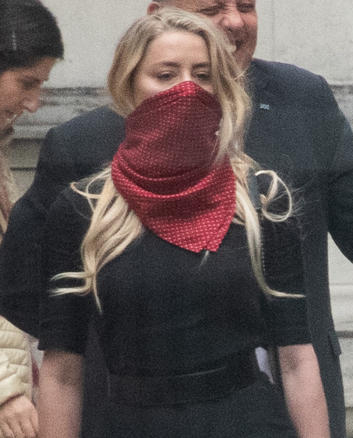 Amber Heard uses a red polka-dot scarf as a face covering