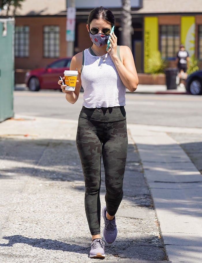 Lucy Hale opts for an athleisure look with a white tank top and camo leggings