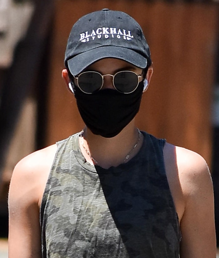 Lucy Hale keeps a low-key look with black face mask, cap, and sunglasses