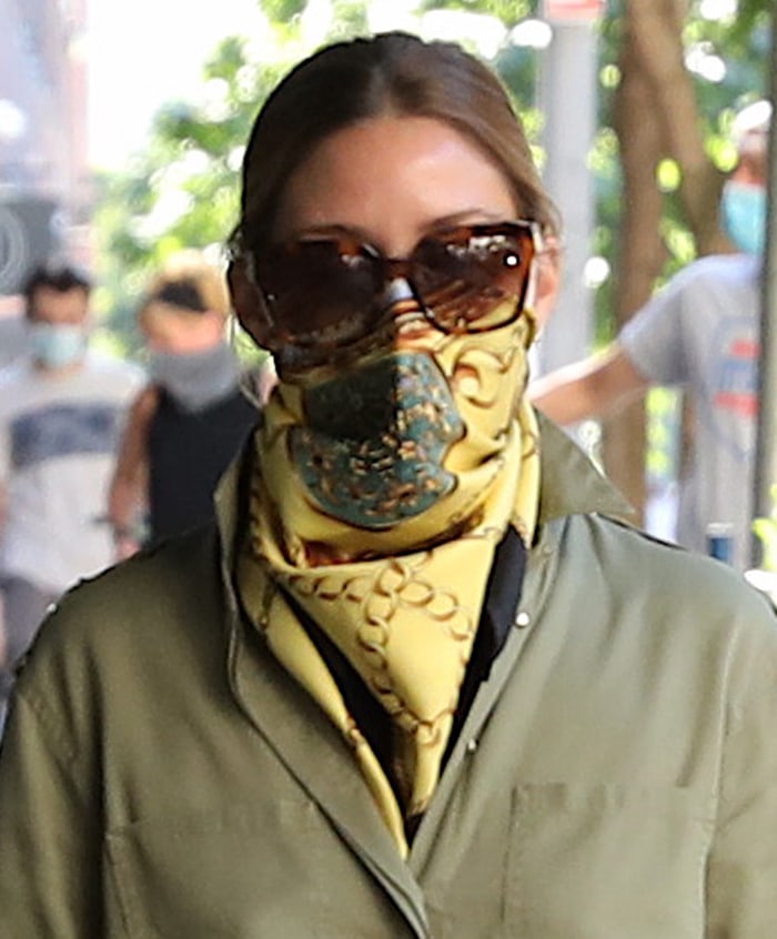 Olivia Palermo stays safe in style with a yellow silk scarf covering her face mask