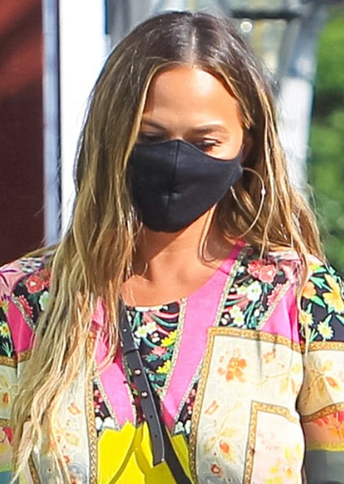 Chrissy Teigen wears a face mask and lets her long tresses down 