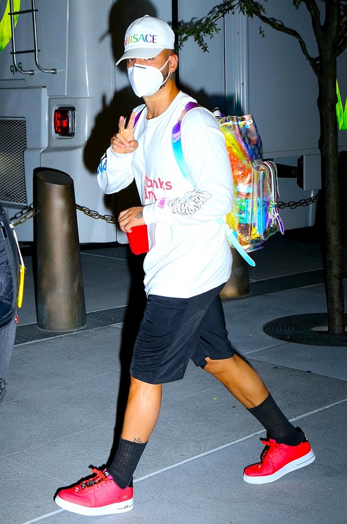 Maluma, sporting red Nike Air Force 1s shoes and a holographic Louis Vuitton backpack, exudes casual cool