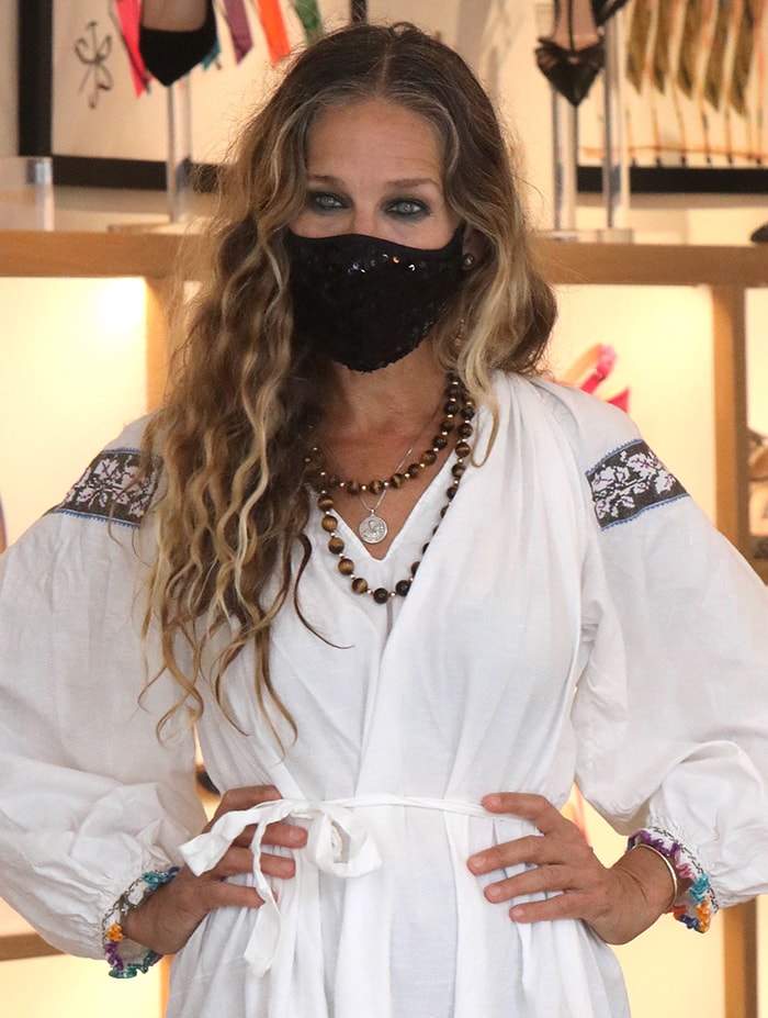 Sarah Jessica Parker wears a bead necklace and a sequined face mask