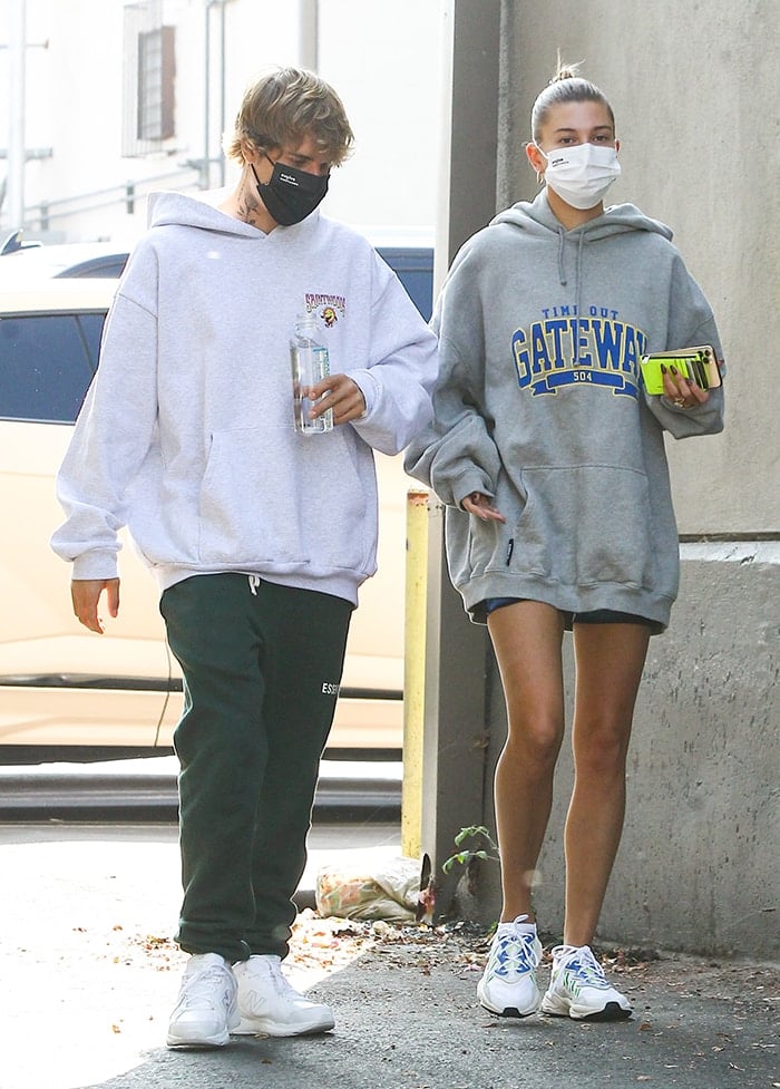 Justin Bieber wears a Saintwoods gray hoodie with Fear of God green sweatpants and white New Balance sneakers