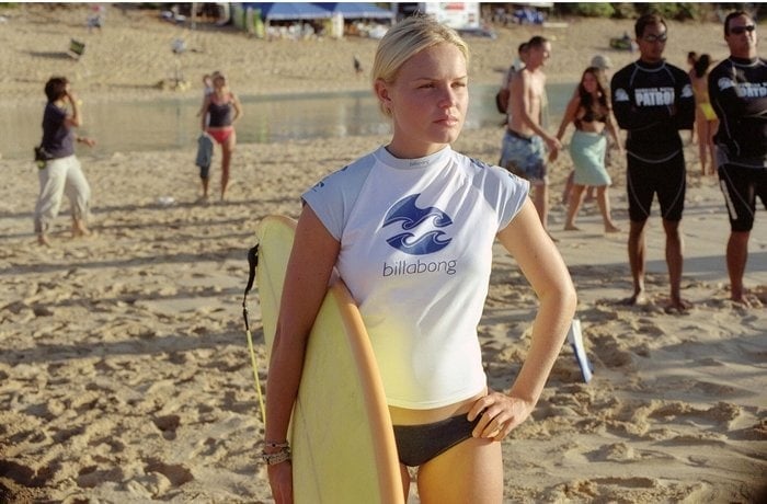 Kate Bosworth carrying a yellow surfboard in Blue Crush