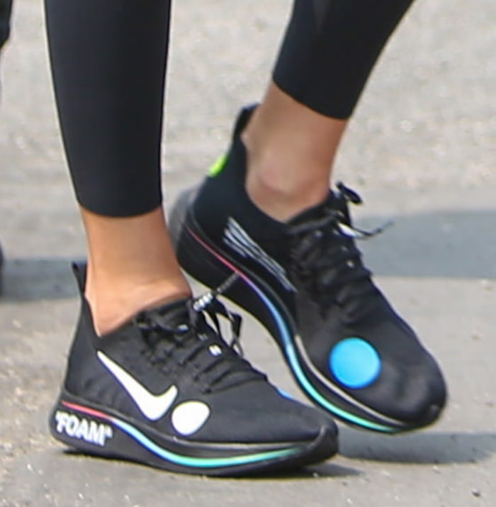 Kendall Jenner slips into a pair of Off-White x Nike Mercurial Flyknit shoes