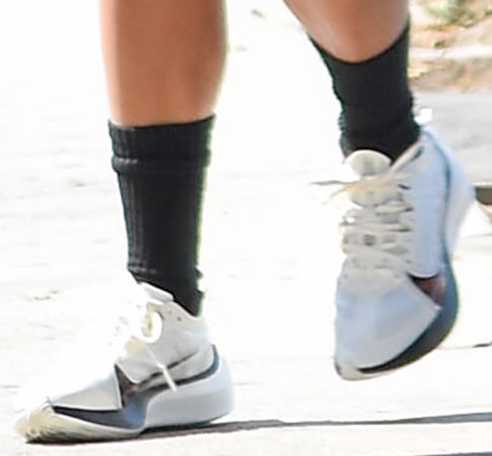 Vanessa Hudgens teams her outfit with high black socks and Nike Zoom Gravity shoes